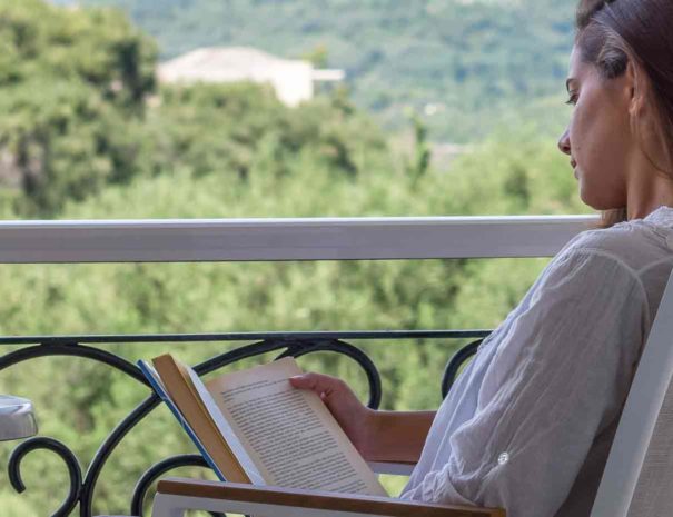 Frau liest Buch auf dem Panorama Balkon